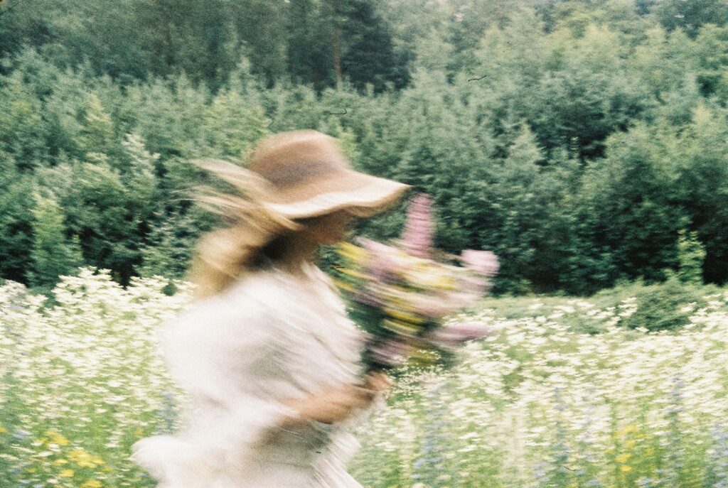 Woman in a hat with flowers in a field